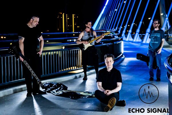A night photo with John, Phaedrus, Adam, and Charles (Echo Signal in 2016) the blue-lit Lowry Avenue bridge over the Mississipi.